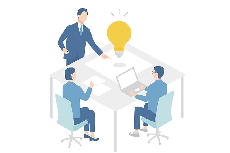 3人で机を囲んで打ち合わせをしている