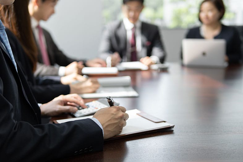 4人で机を囲んで打ち合わせをしている